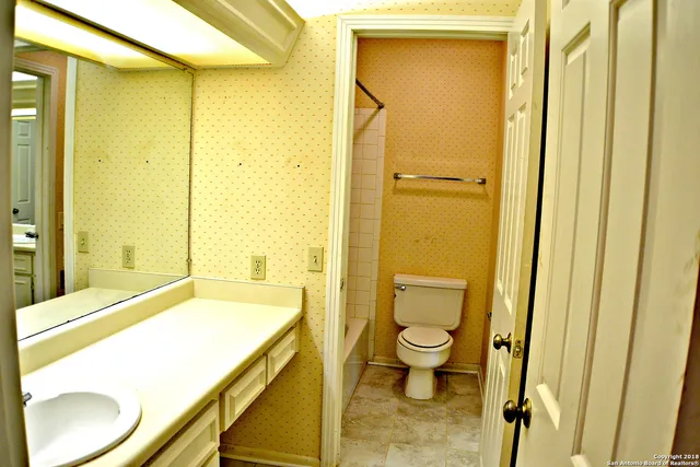 a bathroom with a granite countertop sink toilet and shower