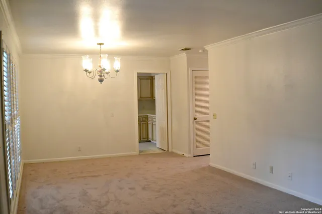 an empty room with a chandelier fan