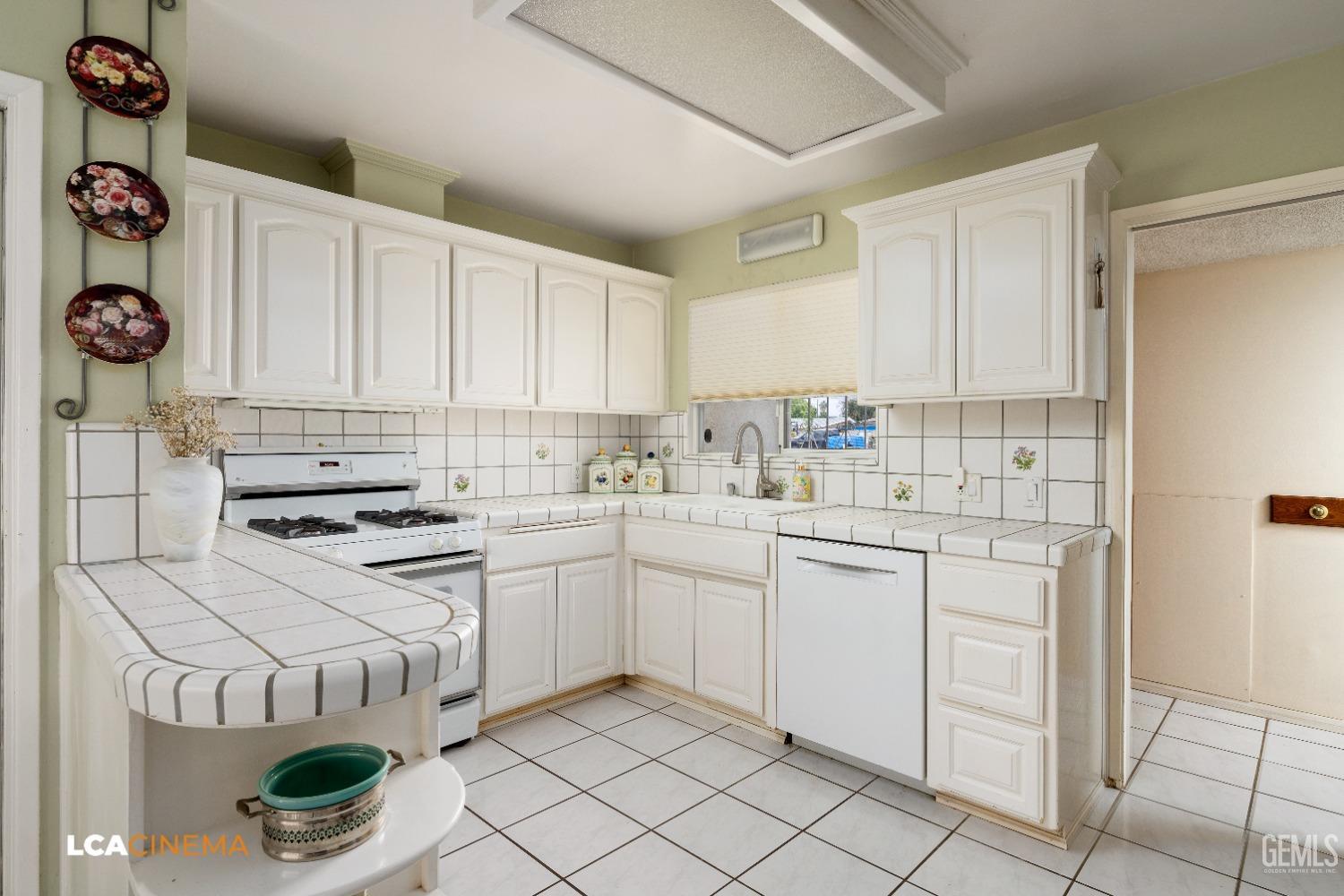 Undisclosed Address Bakersfield, CA 93306 - Photo 14 of 27 a kitchen with white cabinets and white appliances