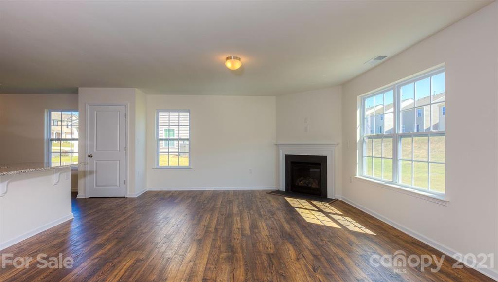 328 Gaines Road Clover, SC 29710 - Photo 12 of 34 an empty room with windows fireplace and wooden floor