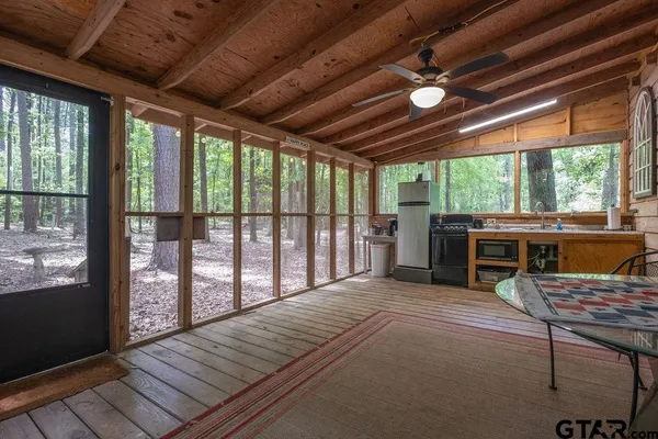 a view of a porch with furniture and wooden floor