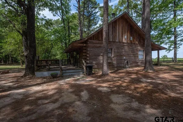a view of house with backyard and trees