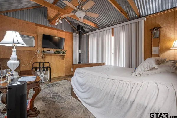 a bedroom with a bed a flat screen tv and dresser