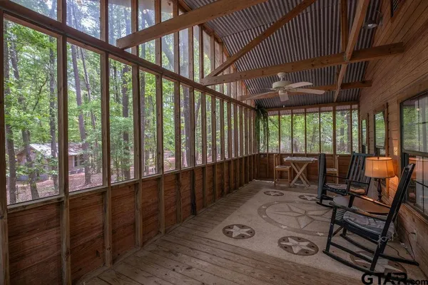 a view of a porch with furniture and floor to ceiling window