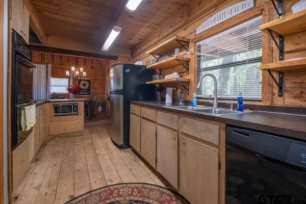 a kitchen with stainless steel appliances granite countertop a sink and wooden cabinets