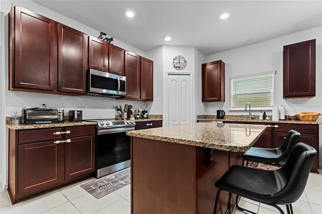 a kitchen with stainless steel appliances granite countertop a sink wooden cabinets and a refrigerator