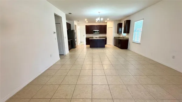 a view of open kitchen with stainless steel appliances a refrigerator and microwave