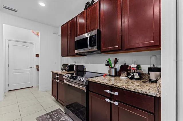 a kitchen with granite countertop stainless steel appliances and cabinets