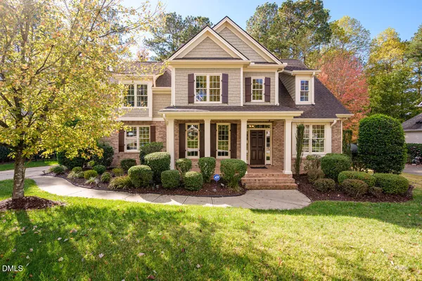 a front view of a house with yard and green space
