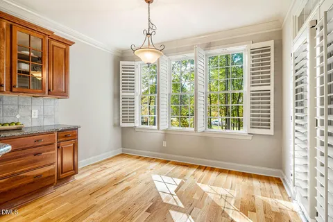 a view of an empty room with a window and chandelier
