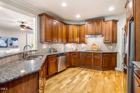 a kitchen with stainless steel appliances granite countertop a sink stove and cabinets