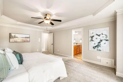 a spacious bedroom with a bed and a chandelier