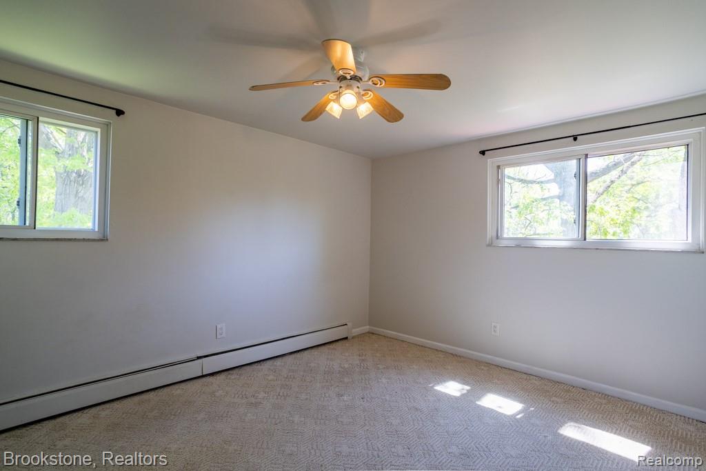 30100 Armada Ridge Road Richmond, MI 48062 - Photo 17 of 29 Spacious room with dual windows, overhead ceiling fan with lighting, wall-to-wall carpeting, and baseboard heating