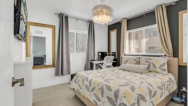 a bedroom with a large bed and a chandelier