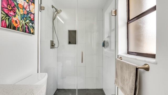 2907 Northeast 8th Terrace, Unit 101 Wilton Manors, FL 33334 - Photo 16 of 24 a bathroom with a bathtub and a shower