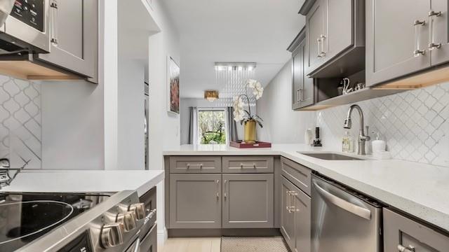 2907 Northeast 8th Terrace, Unit 101 Wilton Manors, FL 33334 - Photo 4 of 24 a kitchen with a sink stove top oven and cabinets