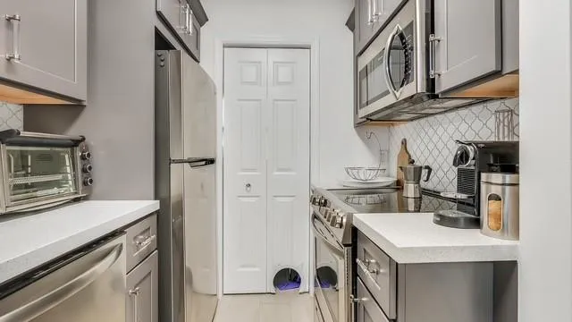 a kitchen with stainless steel appliances granite countertop a sink and a stove