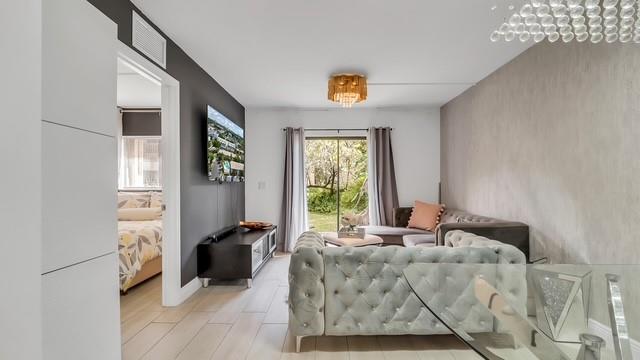 2907 Northeast 8th Terrace, Unit 101 Wilton Manors, FL 33334 - Photo 8 of 24 a living room with furniture and a window