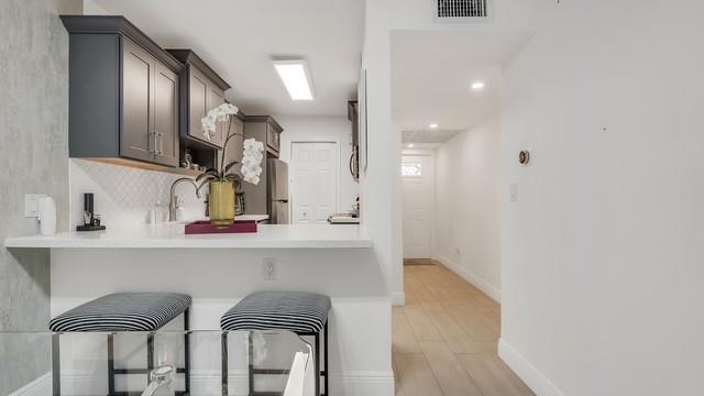 2907 Northeast 8th Terrace, Unit 101 Wilton Manors, FL 33334 - Photo 10 of 24 a kitchen with a table and chairs in it