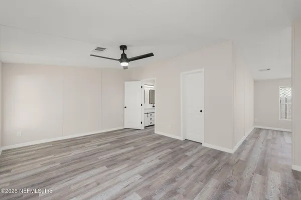a view of a room with wooden floor and a ceiling fan