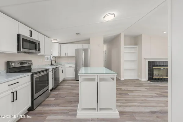 a kitchen with a sink cabinets stainless steel appliances and a counter top space