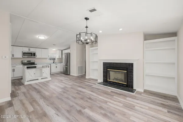 a view of kitchen with granite countertop cabinets and refrigerator