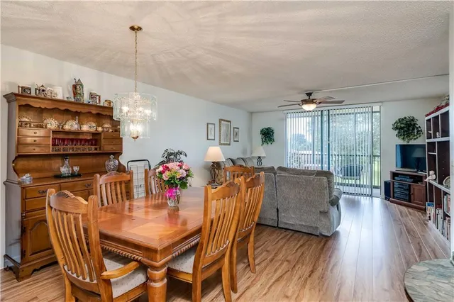 a view of a dining room with furniture a chandelier and wooden floor