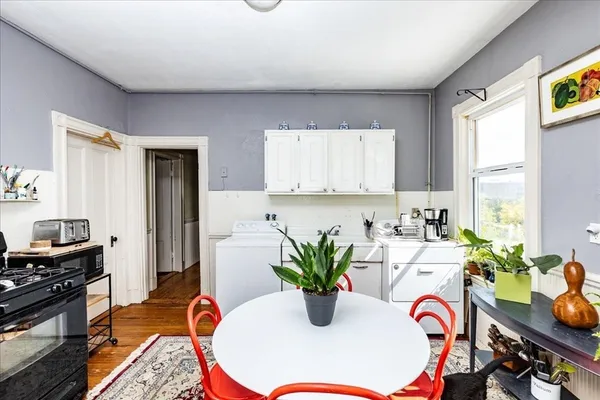 a kitchen with stainless steel appliances granite countertop a dining table with potted plants and wooden floor