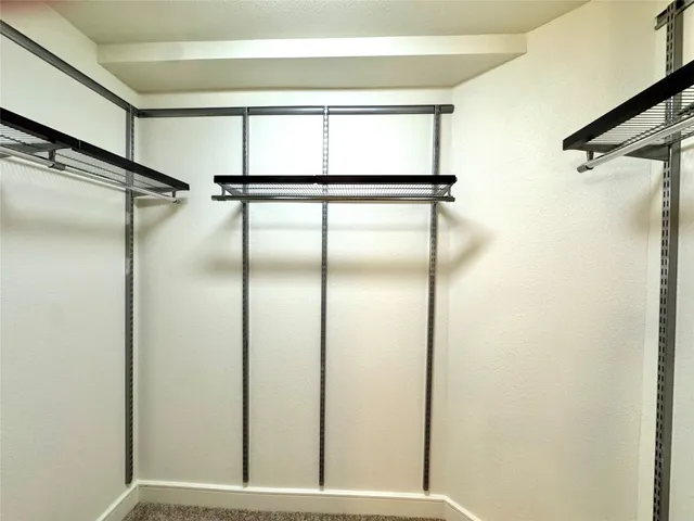 an empty room with a ceiling fan and a window