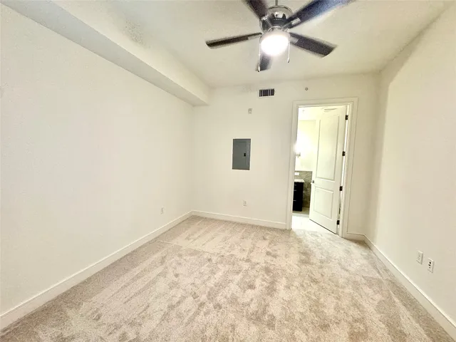 an empty room with closet and a chandelier fan