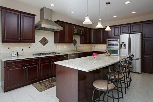 30 Cormier Road Burlington, MA 01803 - Photo 3 of 12 a kitchen with stainless steel appliances kitchen island granite countertop a sink a stove a refrigerator cabinets and a dining table