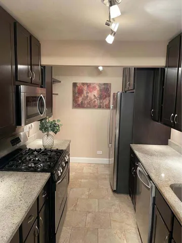 a kitchen with stainless steel appliances granite countertop a stove a refrigerator and a sink