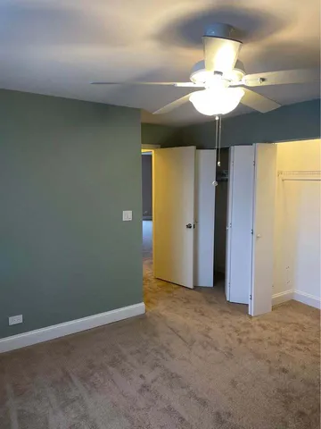 an empty room with a chandelier fan and a chandelier fan