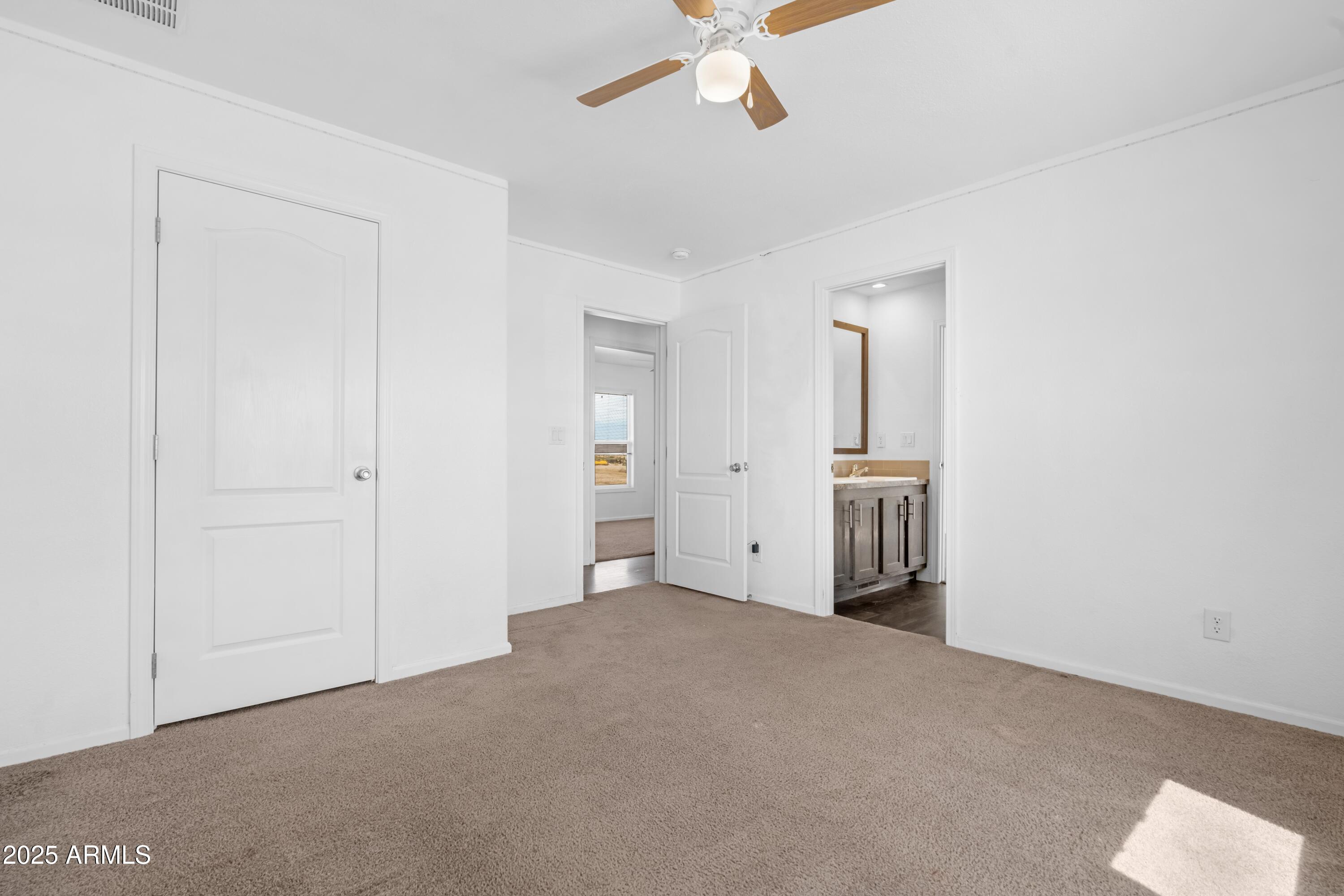 4318 North White Road Maricopa, AZ 85139 - Photo 13 of 21 an empty room with fan and entrance