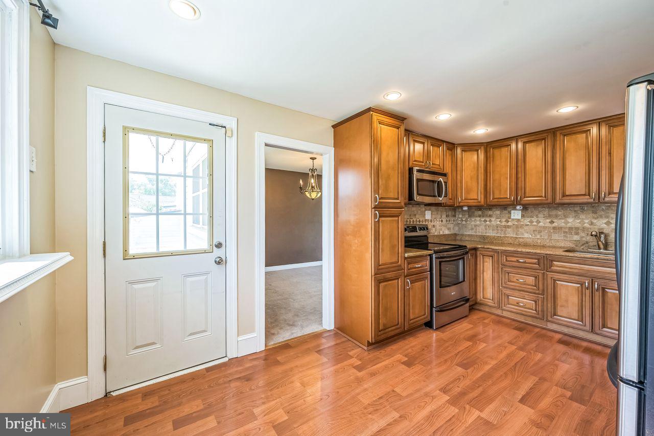 9731 Glenhope Road Philadelphia, PA 19115 - Photo 12 of 36 a kitchen with stainless steel appliances granite countertop a refrigerator stove top oven and sink
