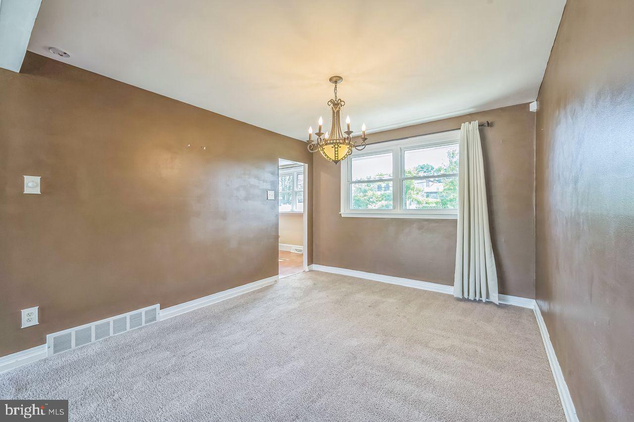 9731 Glenhope Road Philadelphia, PA 19115 - Photo 6 of 36 an empty room with windows and chandelier