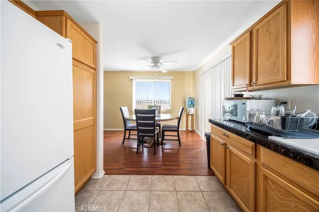 a kitchen with stainless steel appliances granite countertop dining table chairs and a refrigerator