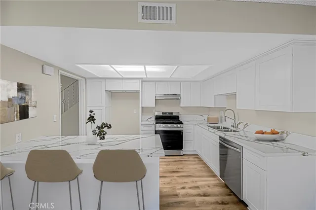 a kitchen with stainless steel appliances a sink stove and cabinets