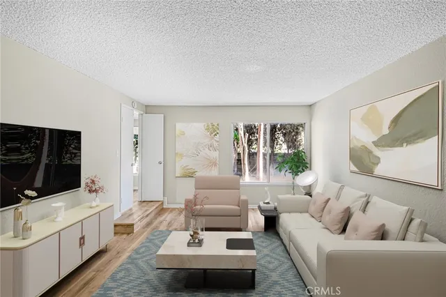 a living room with furniture a flat screen tv and a couch