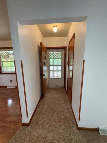 a view of a hallway to rooms