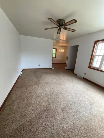 a view of a livingroom with a ceiling fan and window