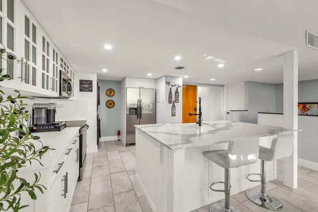 a kitchen with stainless steel appliances granite countertop a refrigerator and a stove top oven