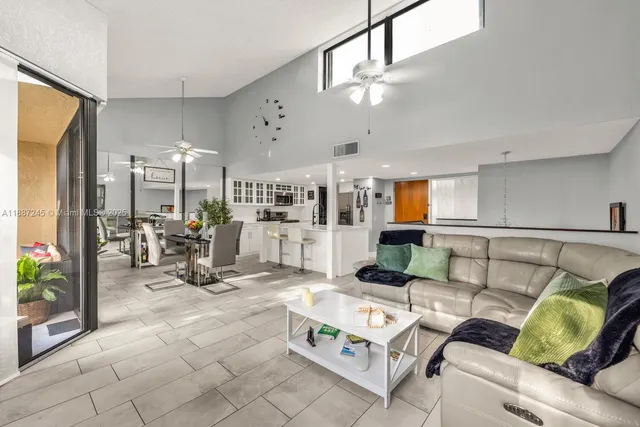 a dining room with stainless steel appliances kitchen island granite countertop a dining table chairs and view kitchen