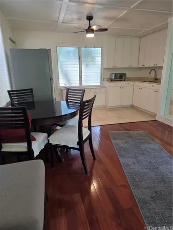 a kitchen with a table chairs a sink dishwasher window and cabinets