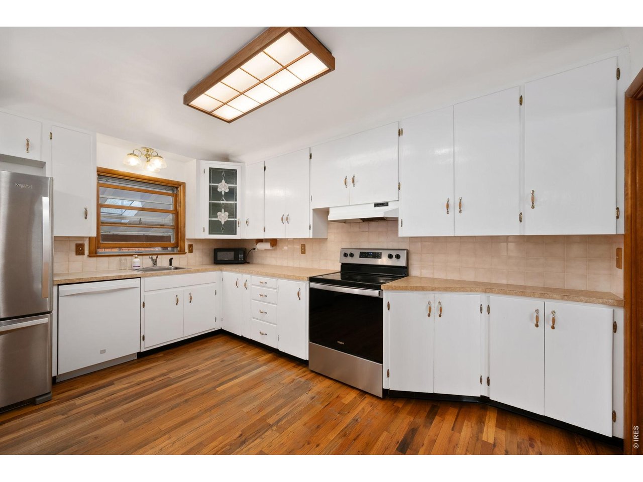 805 Walnut Street Windsor, CO 80550 - Photo 11 of 36 a kitchen with wooden floors and white appliances