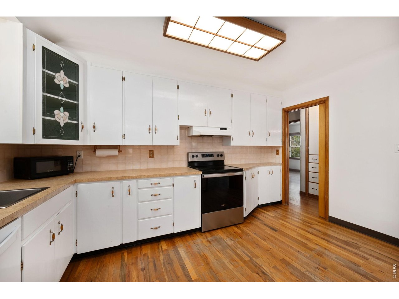 805 Walnut Street Windsor, CO 80550 - Photo 12 of 36 a kitchen with cabinets wooden floor and stainless steel appliances