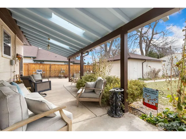 a living room with patio furniture and a floor to ceiling window