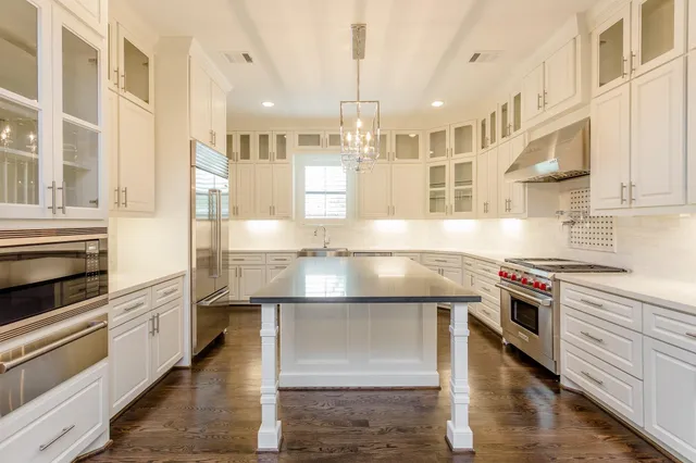 a kitchen with kitchen island granite countertop a stove and a sink