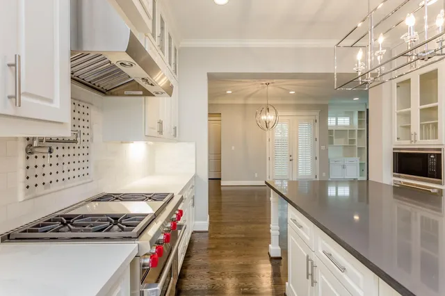 a kitchen with stainless steel appliances granite countertop a stove a sink and a refrigerator