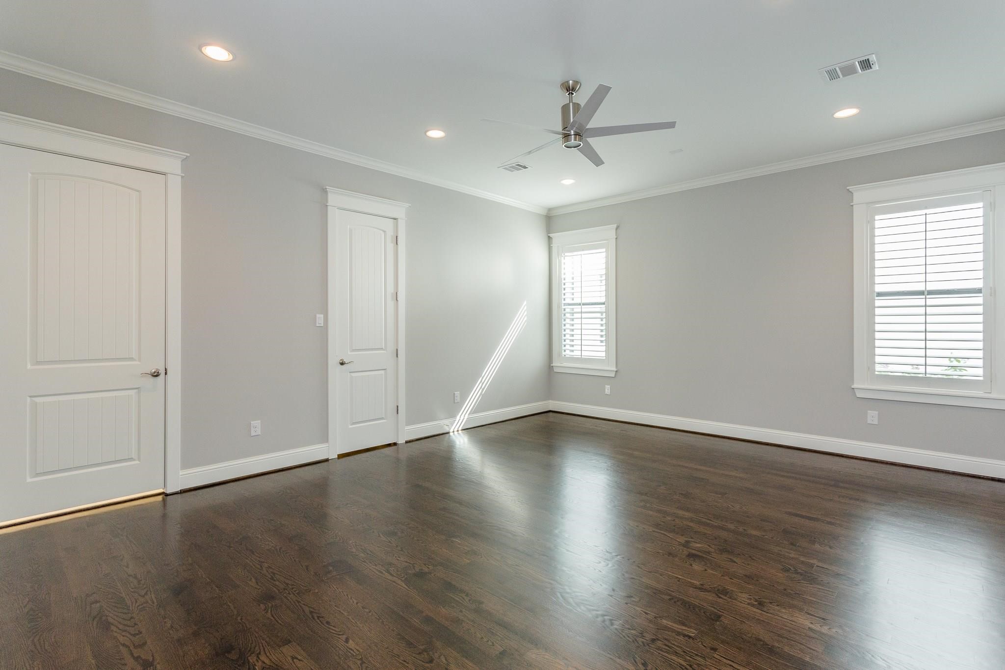 2035 Sheridan Street, Unit A Houston, TX 77030 - Photo 18 of 41 an empty room with wooden floor fan and windows